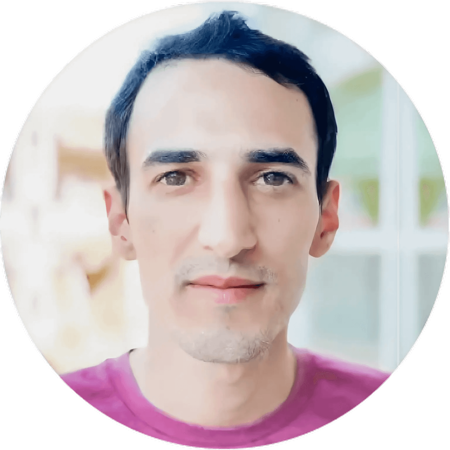 A man with short dark hair and brown eyes, wearing a pink shirt, is looking directly at the camera. The softly blurred background with natural light creates a welcoming feel—perfect for an About page for Better Home Buyer.